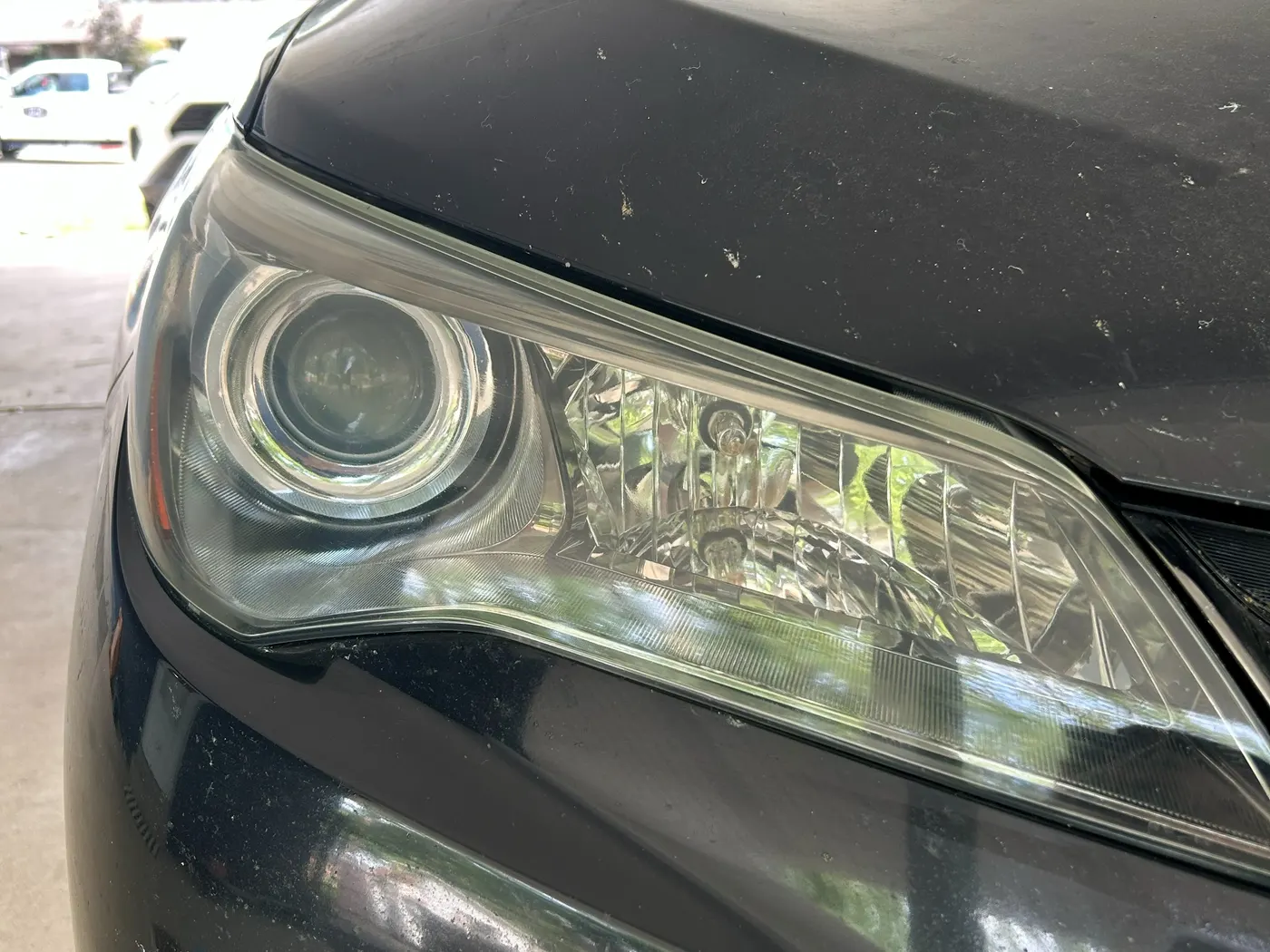 The same Camry headlight after restoration, the lens fully clear with the projector and reflector sharply visible