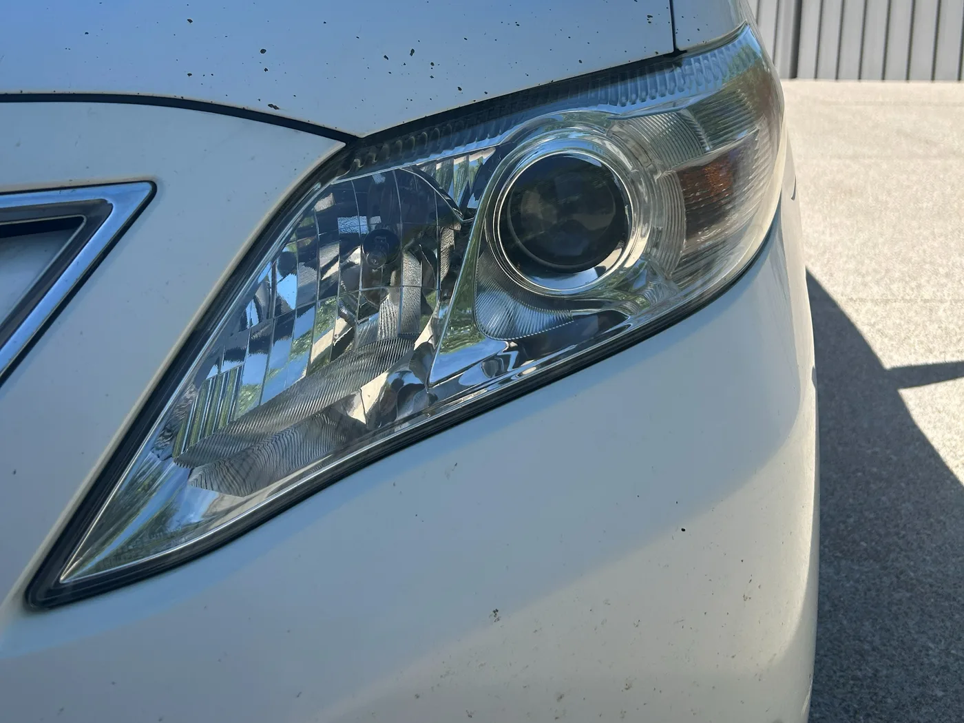 The same driver-side headlight after restoration and UV coating, the chrome reflector and projector lens sharply visible