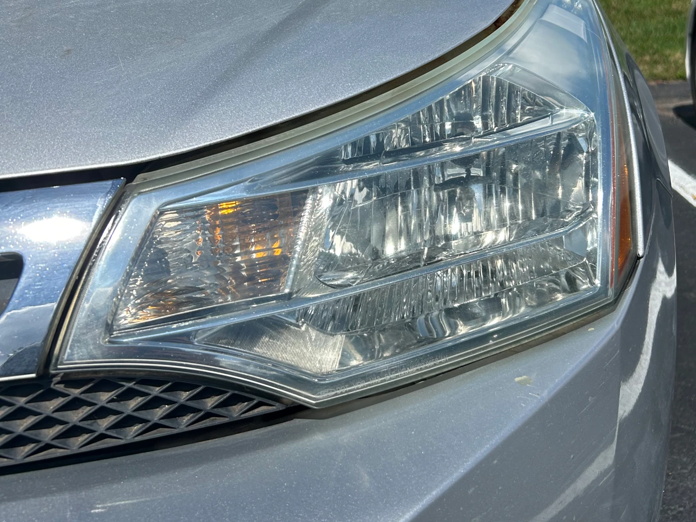 The same driver-side headlight after restoration and UV coating, fully transparent with crisp internal detail