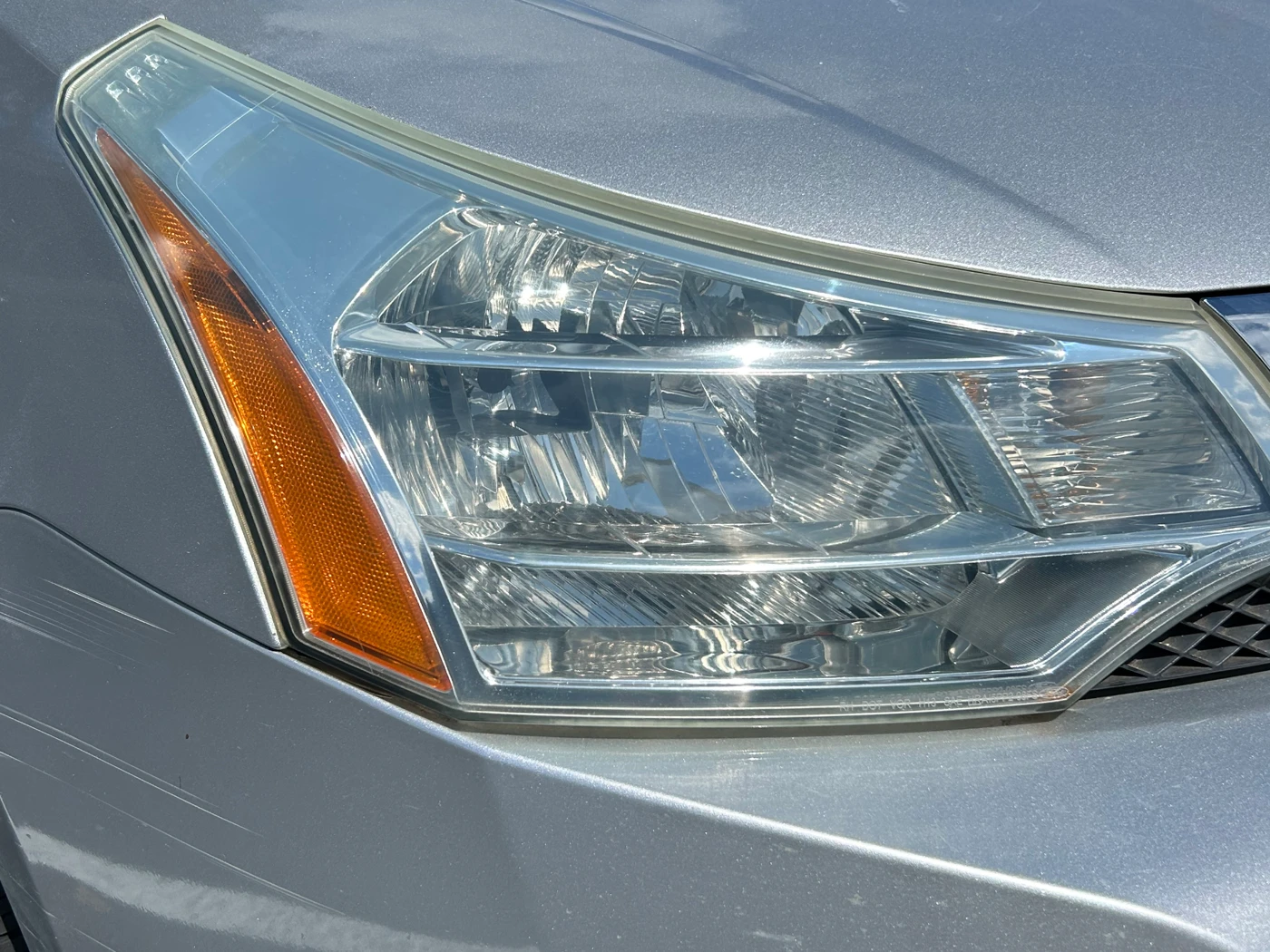 The same passenger-side headlight after restoration, the lens clear with the reflector and amber marker sharply defined