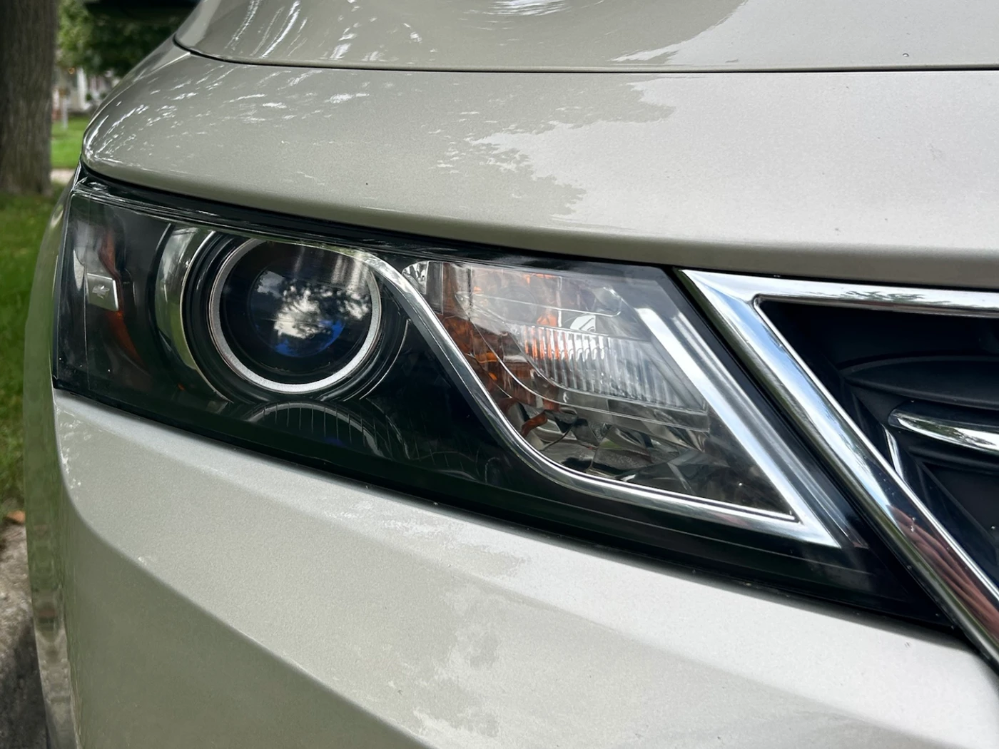 The same Impala headlight after restoration, the lens fully clear with the projector, halo ring and chrome trim sharply visible