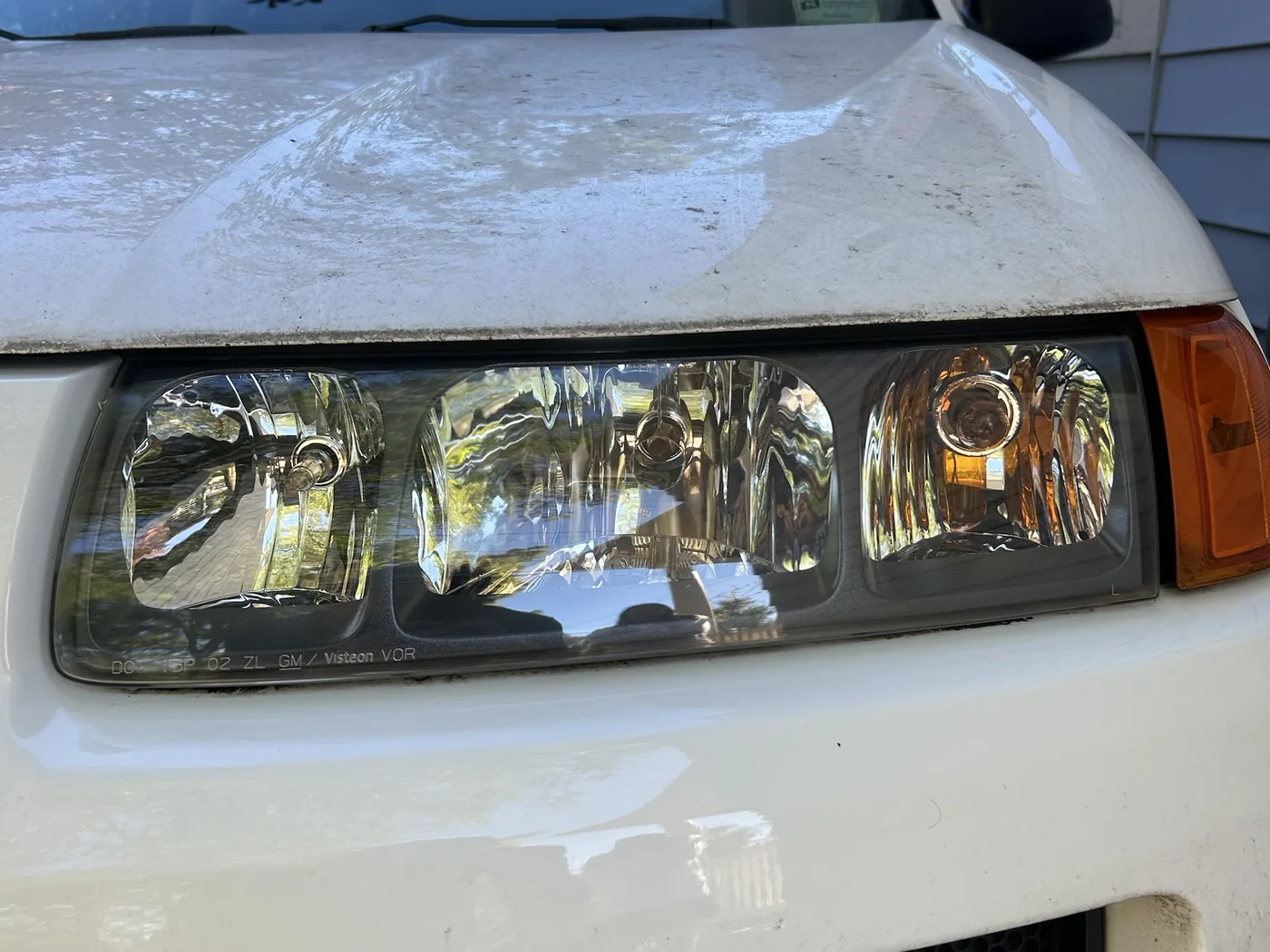 The same headlight close-up after restoration and UV coating, the lens transparent with crisp chrome detail inside